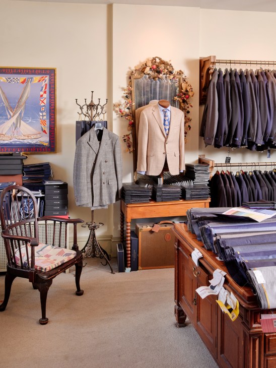 Elegant Cuffs boutique interior with tailored suits, fabric displays and classical architectural details