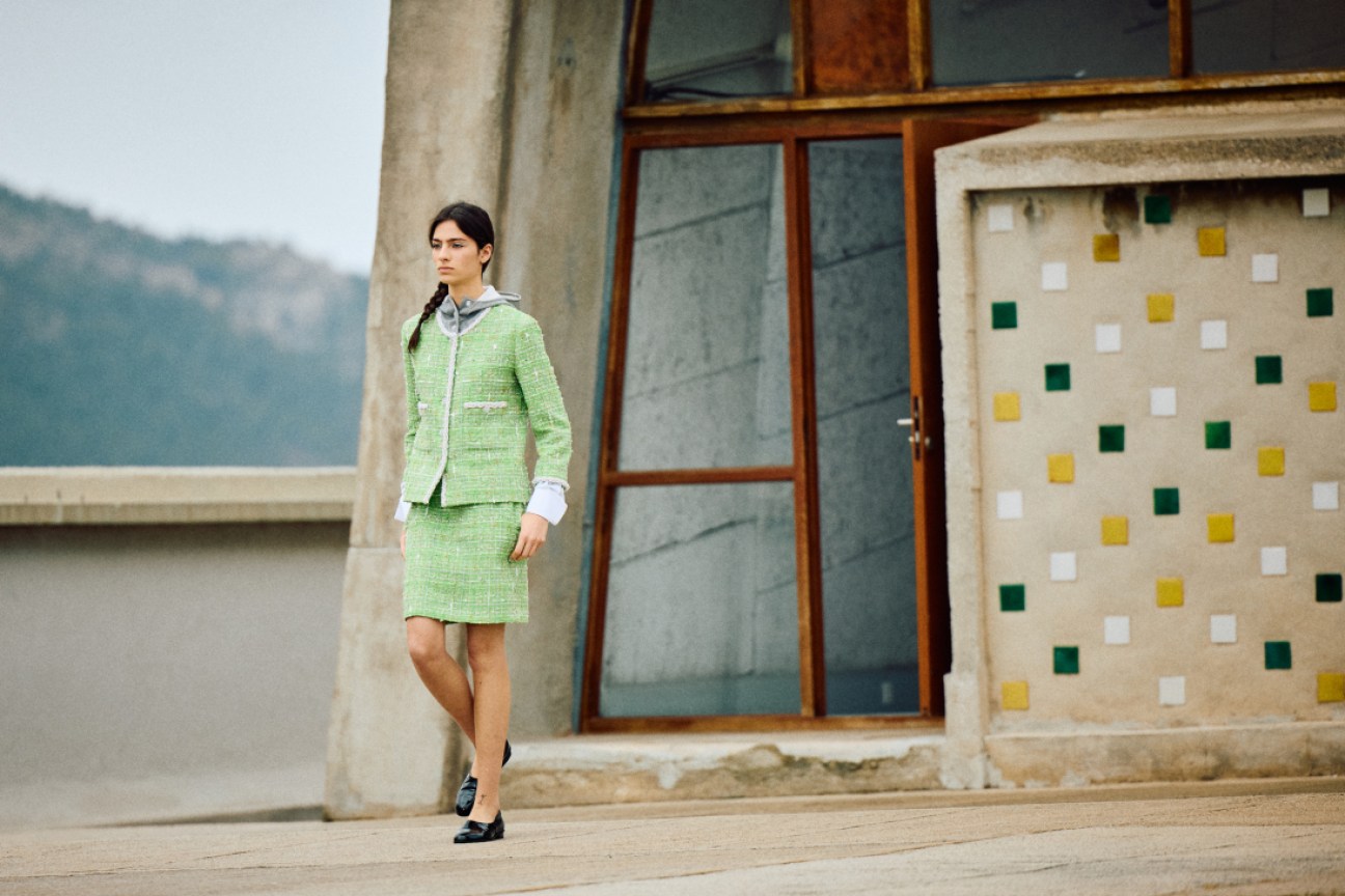 Model in lime-toned Chanel Cruise 2024/25 look at Le Corbusier's Cité Radieuse