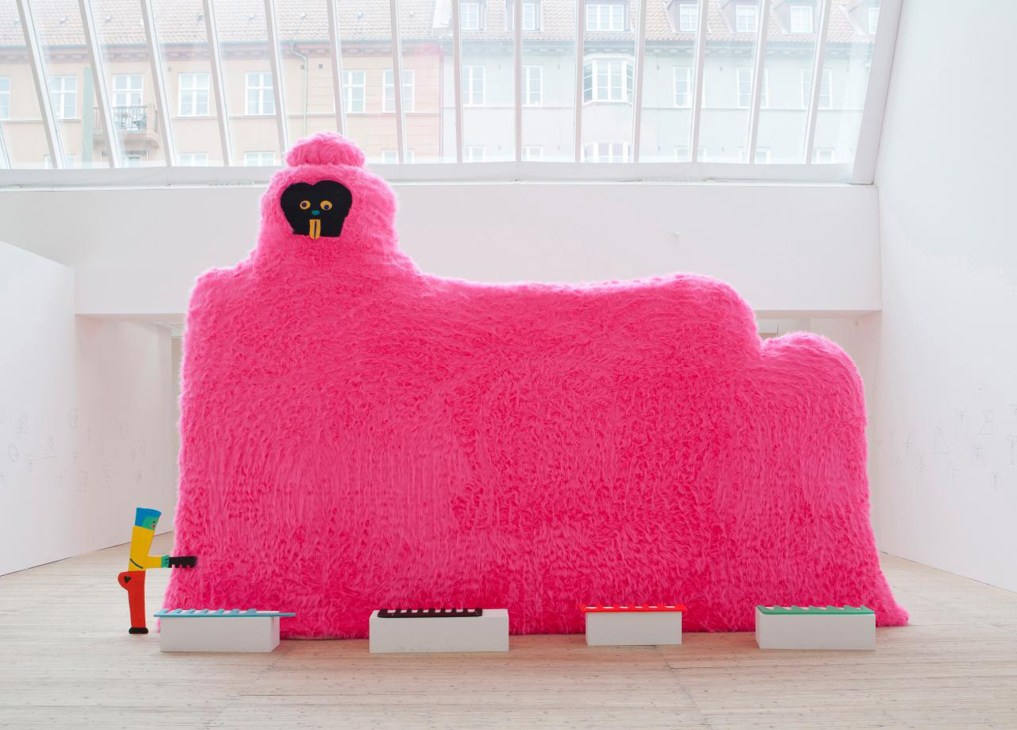Large pink furry sculptural installation by Misaki Kawai in a white gallery space with windows