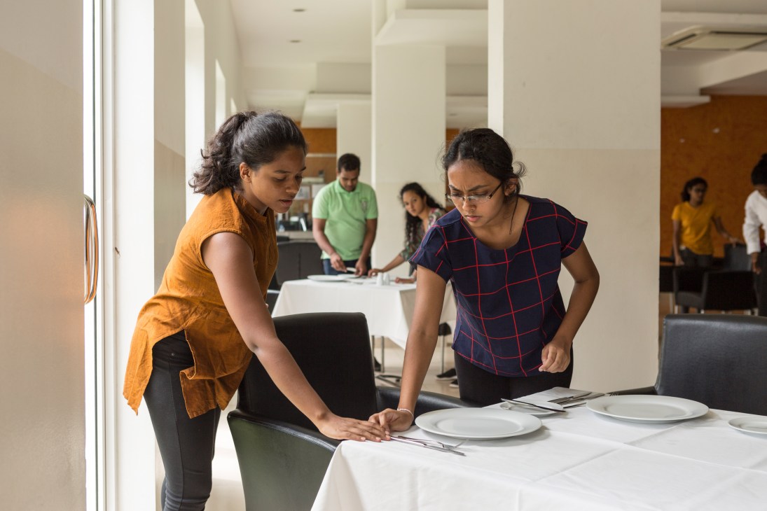 Students setting a dining table at the Colombo Academy of Hospitality in Sri Lanka.