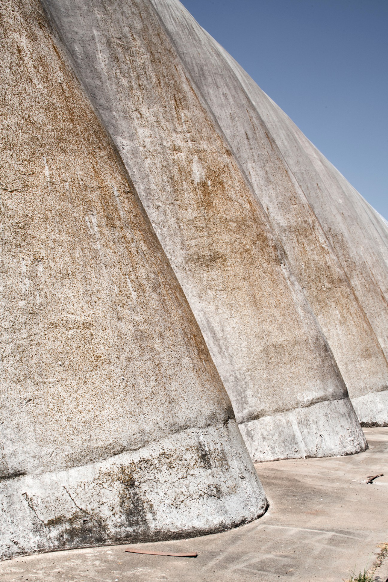 Close-up view of curved concrete wall showing undulating surface pattern with vertical ribbed texture