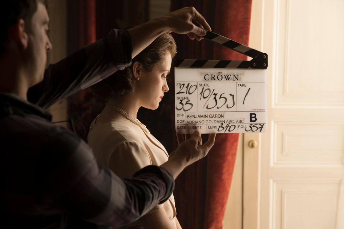 Behind-the-scenes filming of The Crown Netflix series with clapperboard and actress in period costume