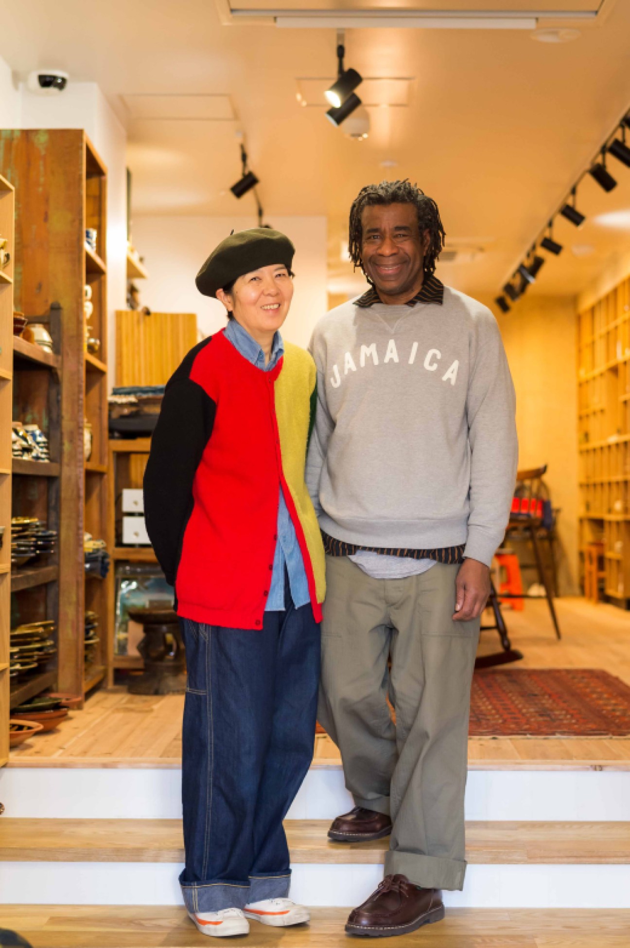 Keiko Kitamura and Terry Ellis standing together in front of their Mogi Folk Art shop