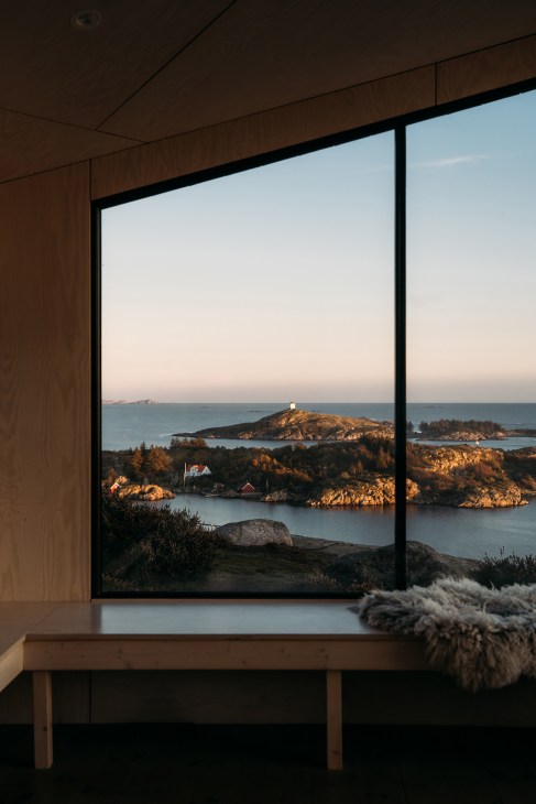 Interior view of minimalist cabin with wooden elements and large windows