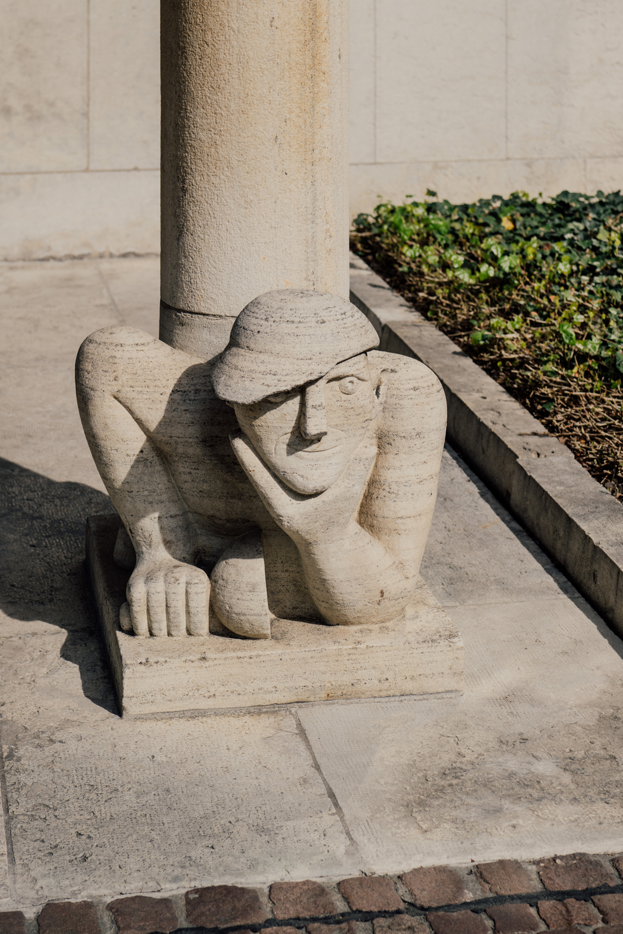 Stone carved sculpture of a figure at the base of a column in Basel