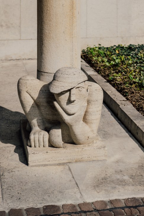 Stone carved sculpture of a figure at the base of a column in Basel