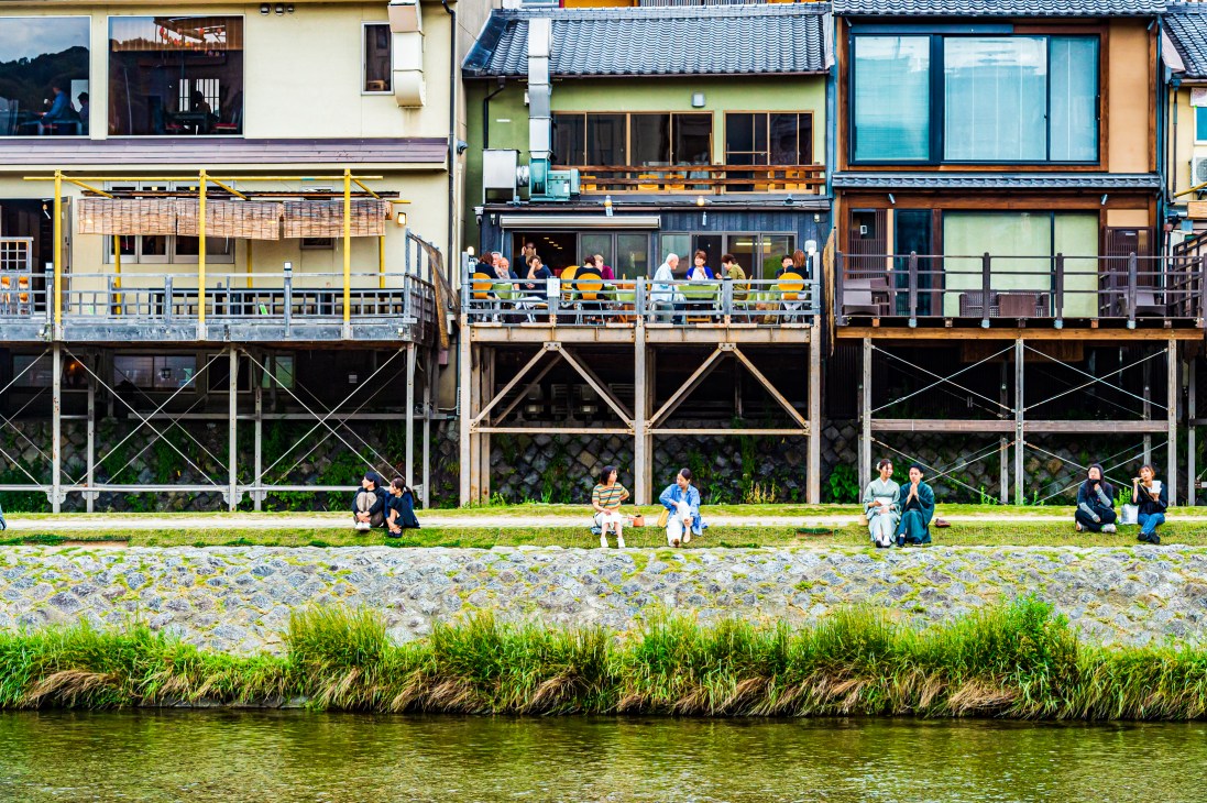 Japanese restaurant buildings, with people sitting on grass in front of it