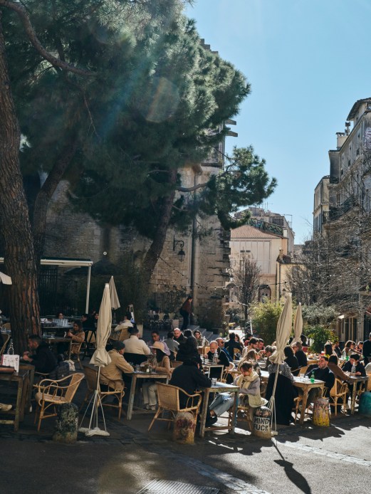 Outdoor café scene in Montpellier old town with people sitting at street-side tables