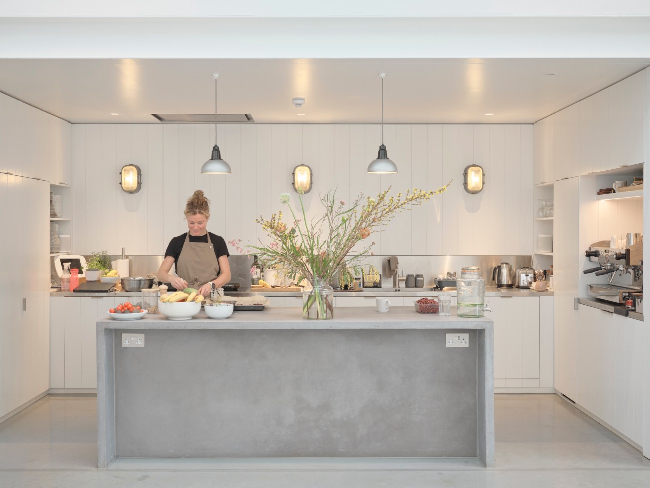 Modern kitchen area in the studio with communal dining table and natural lighting