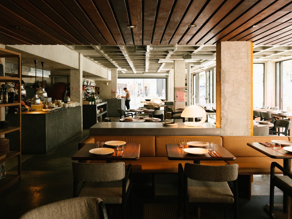Open kitchen at Brutus restaurant with stone benchtop against exposed brick wall creating a stage-like setting