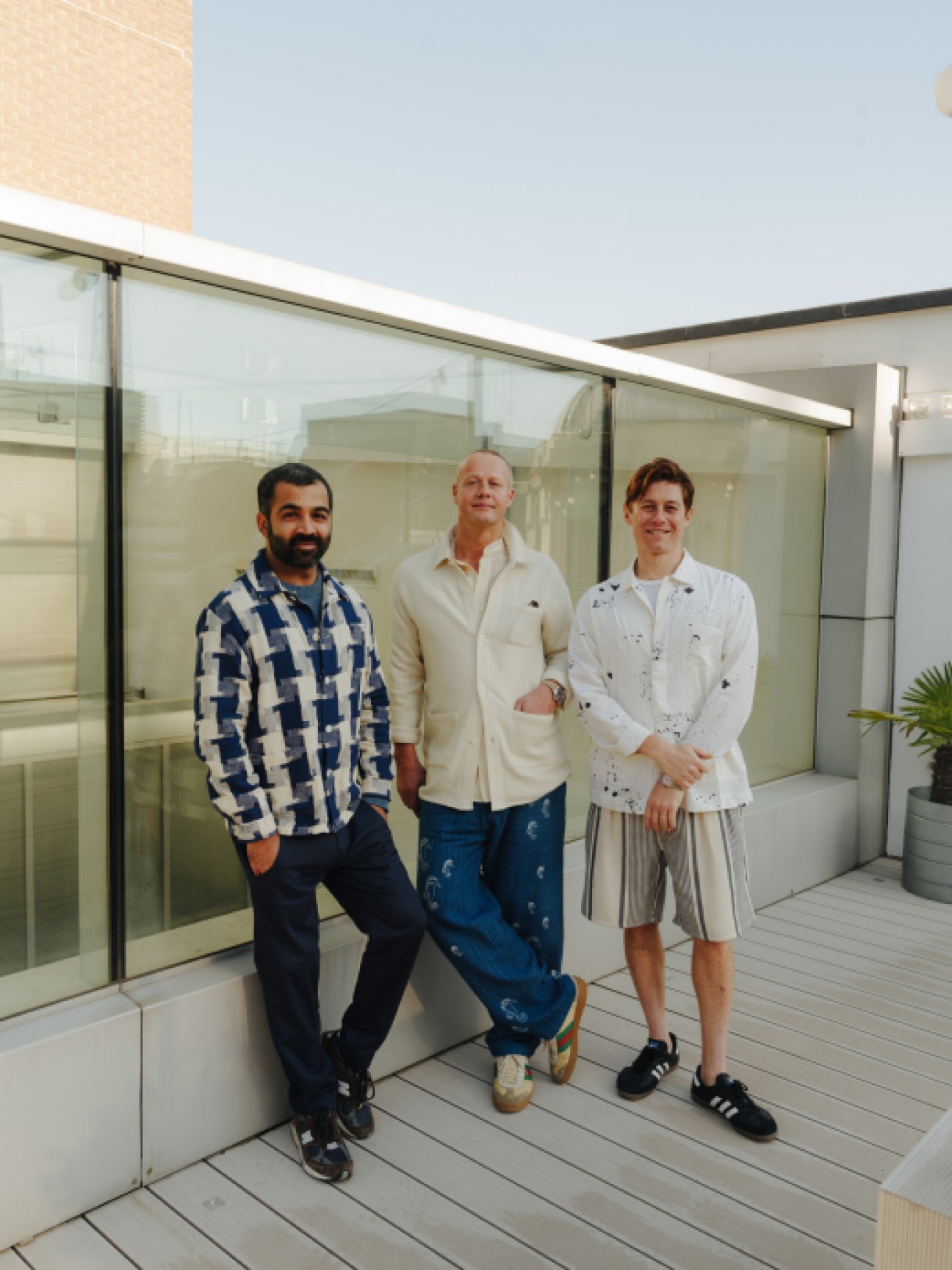 Three SMR Days co-founders Gautam Rajani, Dan May and Adam Shapiro standing together on modern terrace