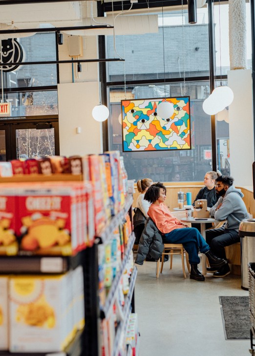 Customers seated at tables eating and socializing in bright modern cafe interior