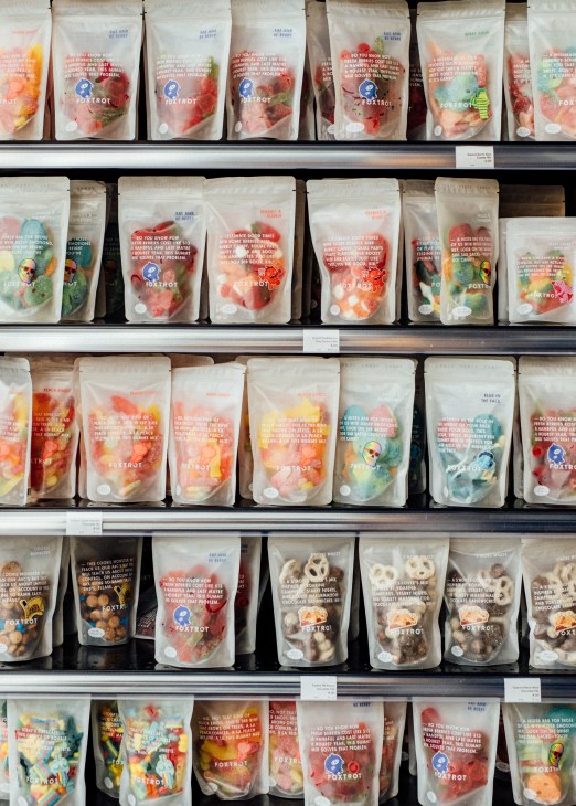 Shelves displaying colorful packaged snacks and gummies in branded Foxtrot pouches