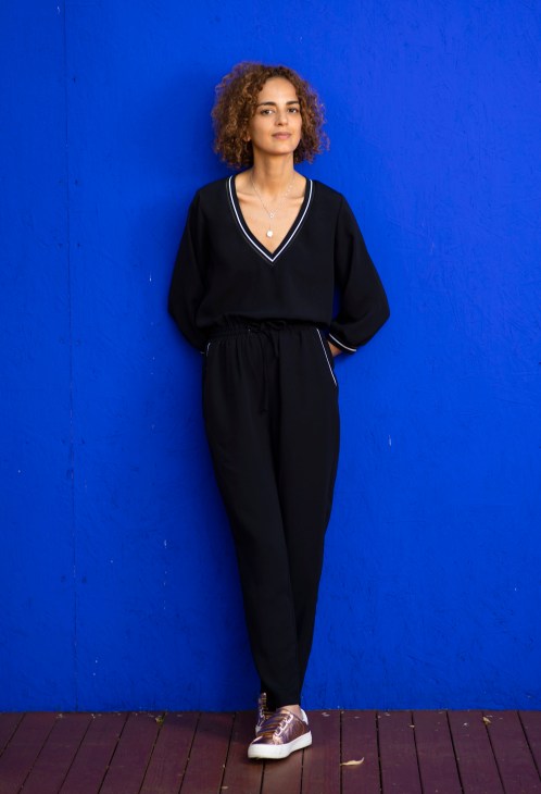 Portrait of author Leïla Slimani sitting at a desk with books