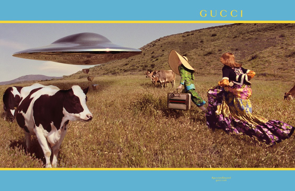 Gucci fashion campaign with models in colorful outfits among cows and a UFO in desert landscape