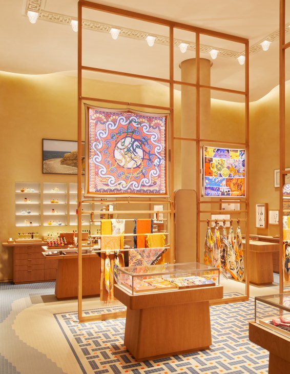 Hermès Barcelona store interior with warm lighting, geometric ceiling patterns, and mosaic tile flooring