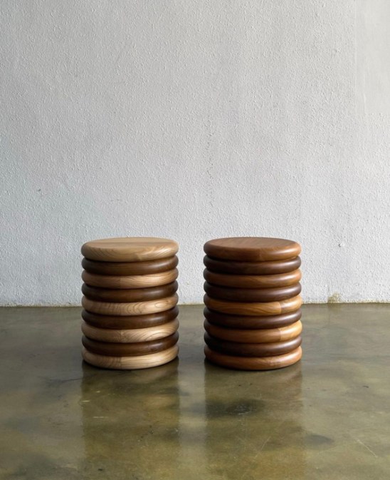 Two wooden Hilu stools with stacked circular disc design by Studio Kallang on polished concrete floor
