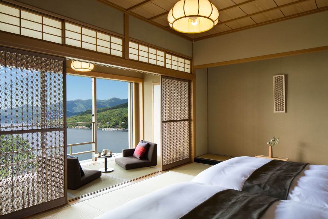 Japanese-style guest room with lake view, featuring tatami mat seating area and modern furnishings at Hoshino Resorts Kai Nikko.