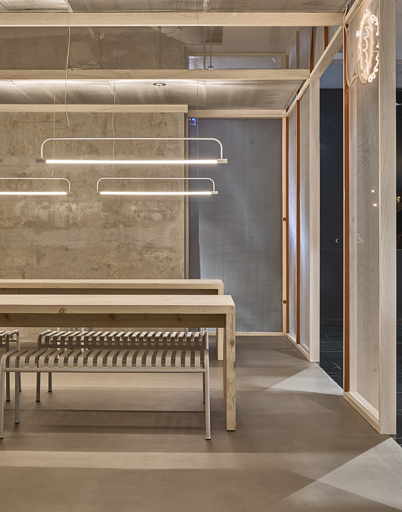 Modern cinema interior with wooden fixtures, pendant lighting, and glass-walled spaces