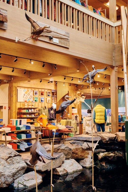 Interior of LL Bean flagship store in Maine with wooden railings, taxidermy birds, and outdoor gear displays