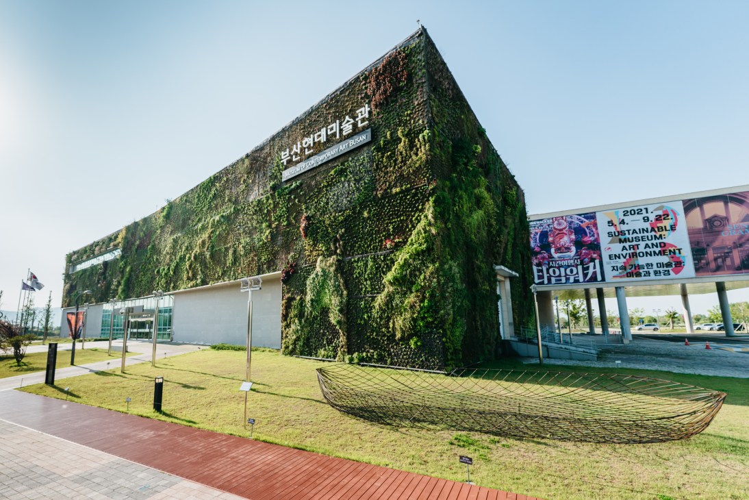 Museum of Contemporary Art Busan exterior with living wall facade and exhibition banners