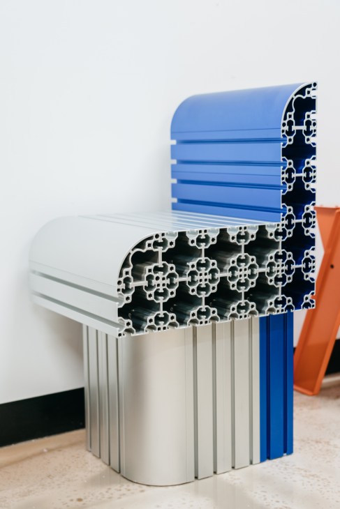 Pattern of Industry furniture stool made from repurposed aluminium rods in blue, white and orange.