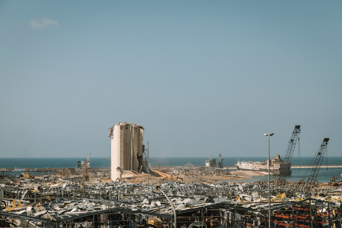 Aerial view of Beirut port showing massive destruction with twisted metal, destroyed grain silos, and debris