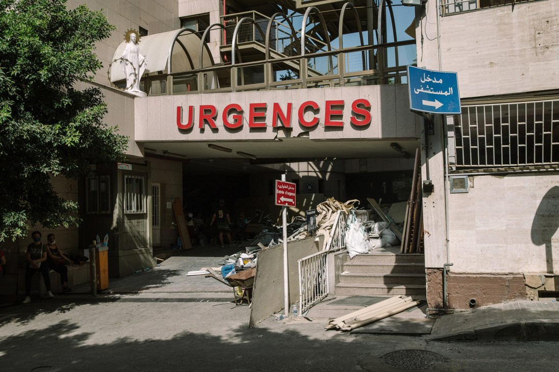 Severely damaged entrance to hospital emergency department with broken windows, collapsed ceiling, and debris