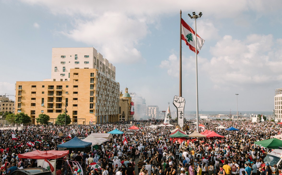 Large crowd of Lebanese protesters filling a square with flags and signs after learning the government knew about the dangerous ammonium nitrate