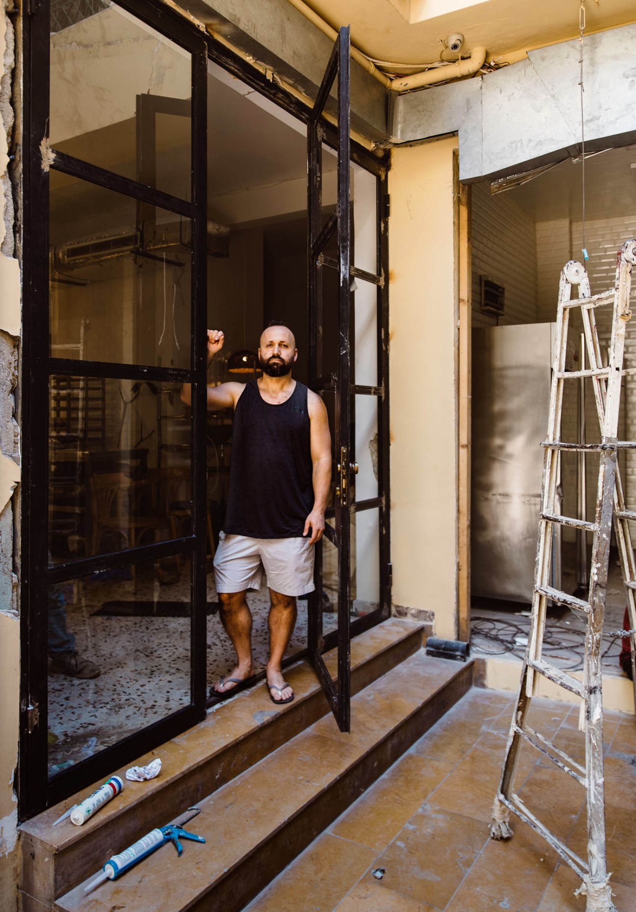Brant Stewart standing in his damaged Mavia bakery amid construction materials and debris from the Beirut explosion