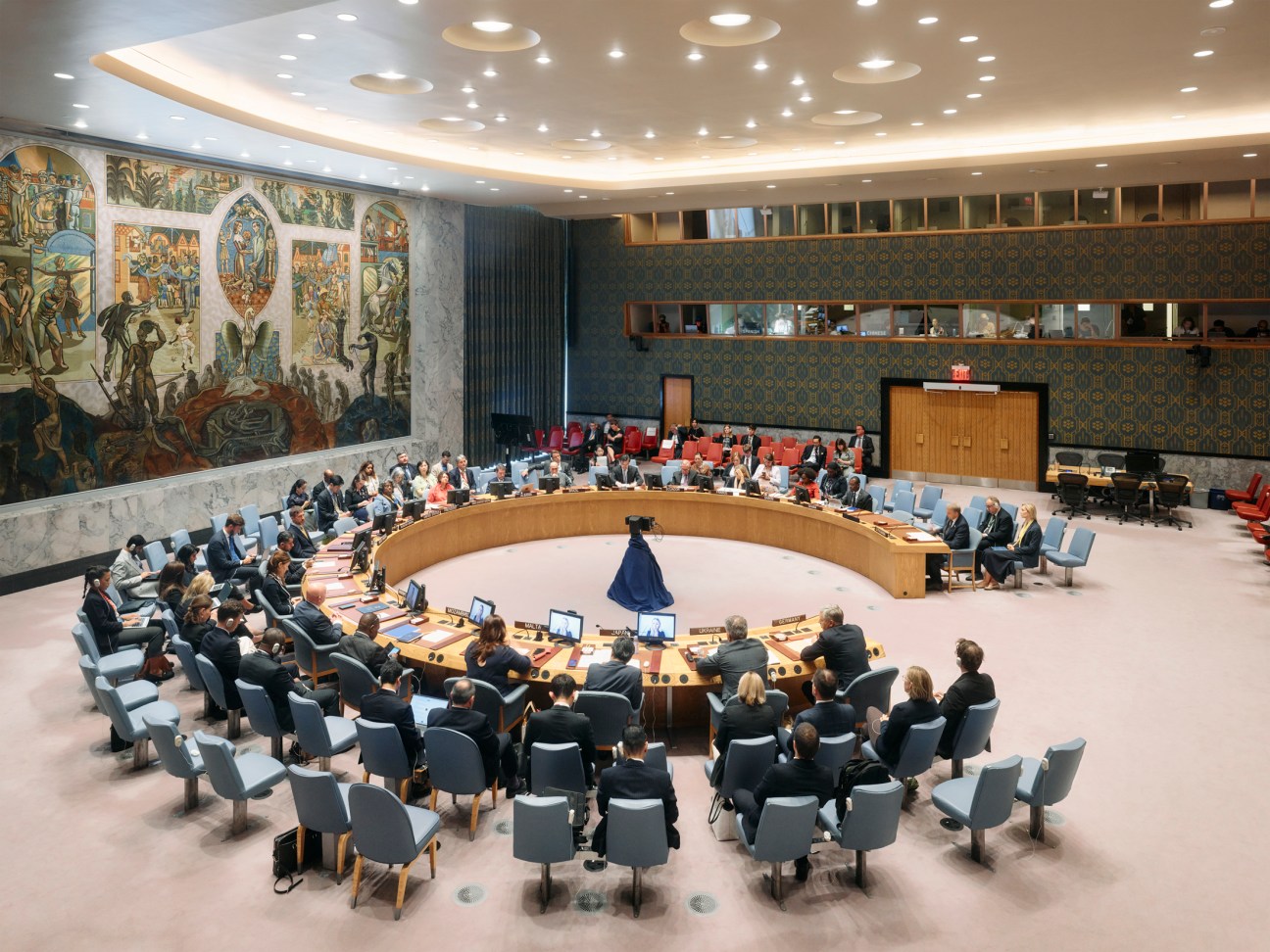 UN Security Council chamber with ambassadors seated around the curved desk during a formal session