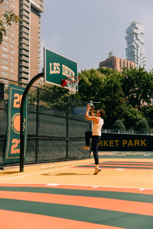 Players using the renovated basketball courts with Les Deux's colourful striped design