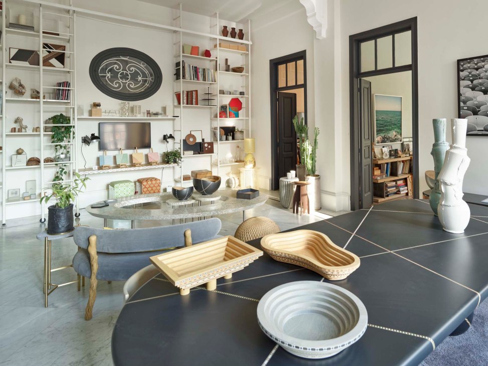 Interior of Nada Debs' design studio featuring white shelving, furniture displays, and decorative objects.
