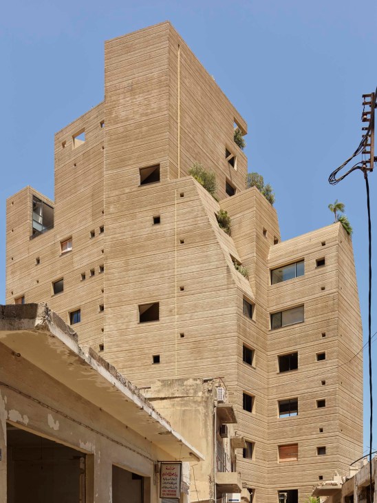 Stone Garden apartment building in Beirut with distinctive hand-combed textured facade and irregular window voids designed by Lina Ghotmeh.