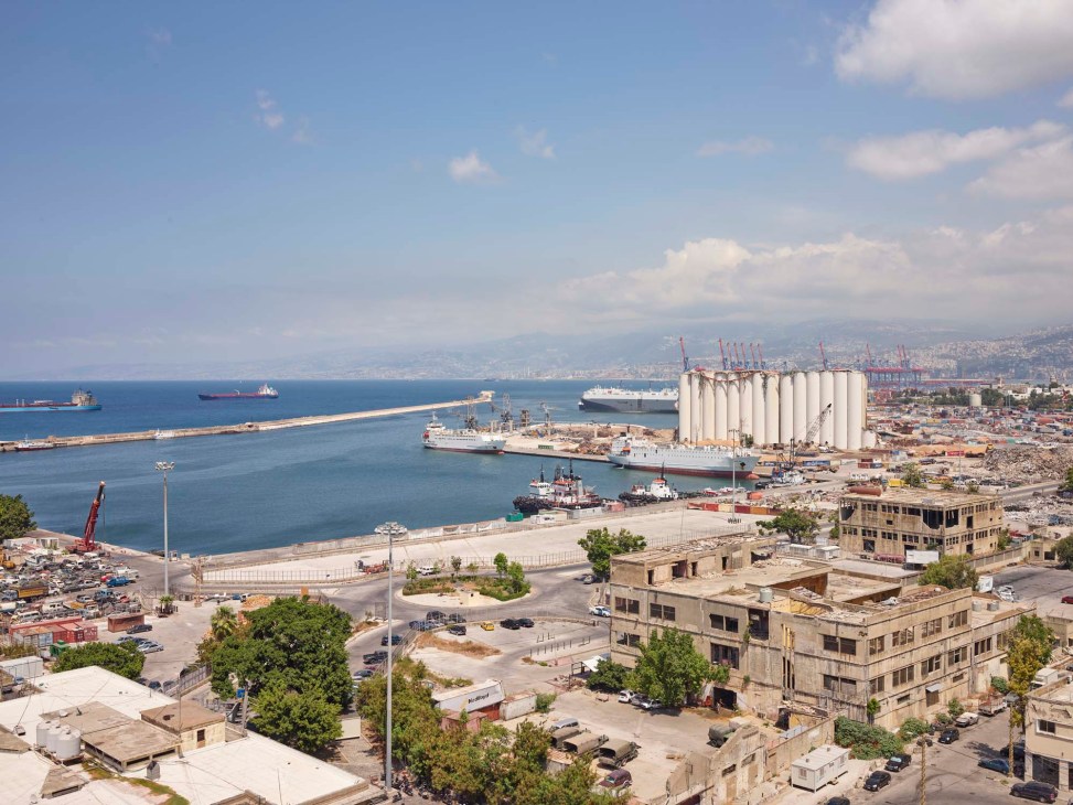 Aerial view of Beirut's port area showing ships, grain silos, and damaged buildings near the explosion site