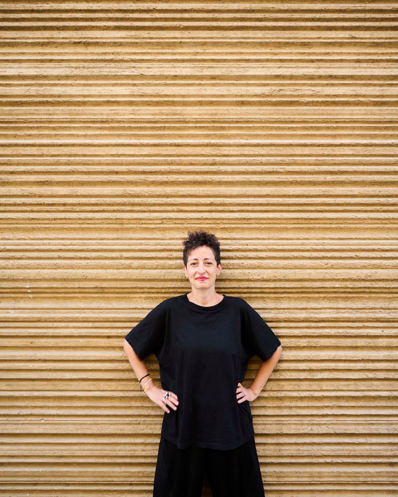 Architect Lina Ghotmeh standing in front of her Stone Garden building in Beirut