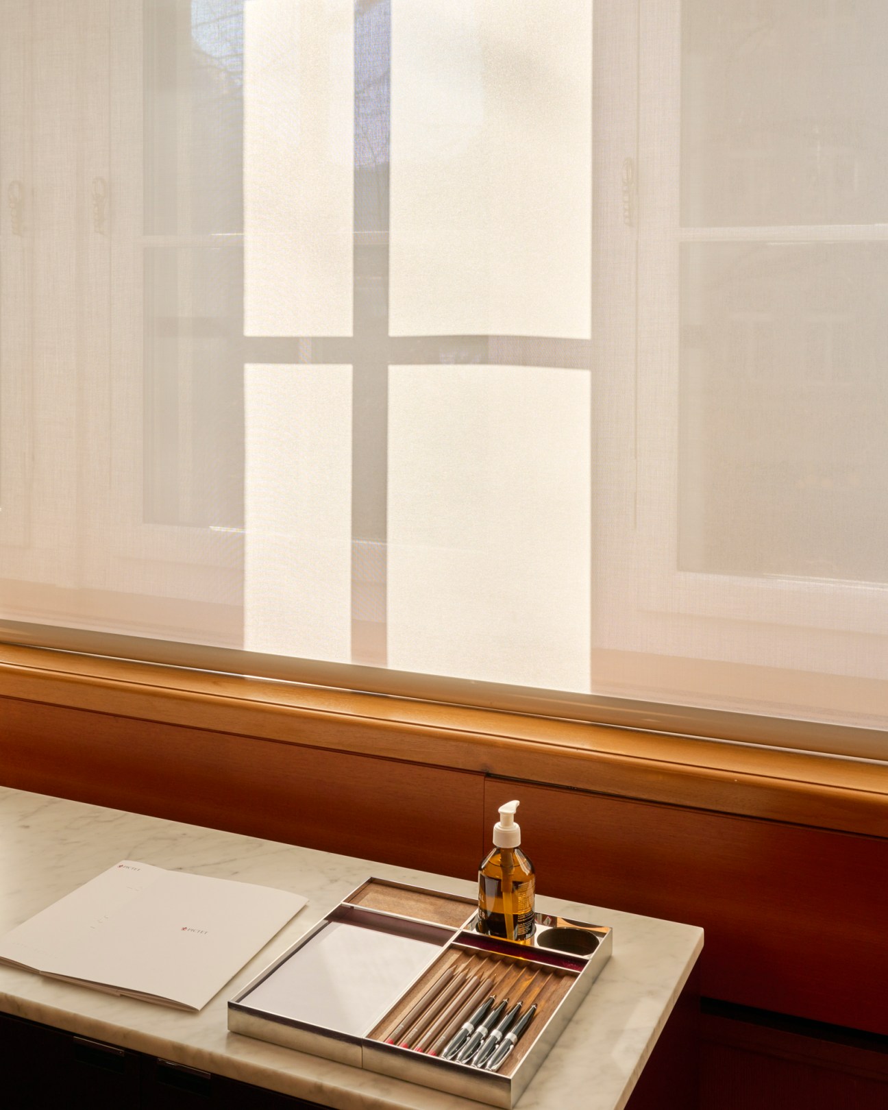 Stationery organiser designed by Kunstgiesserei on marble surface with window view