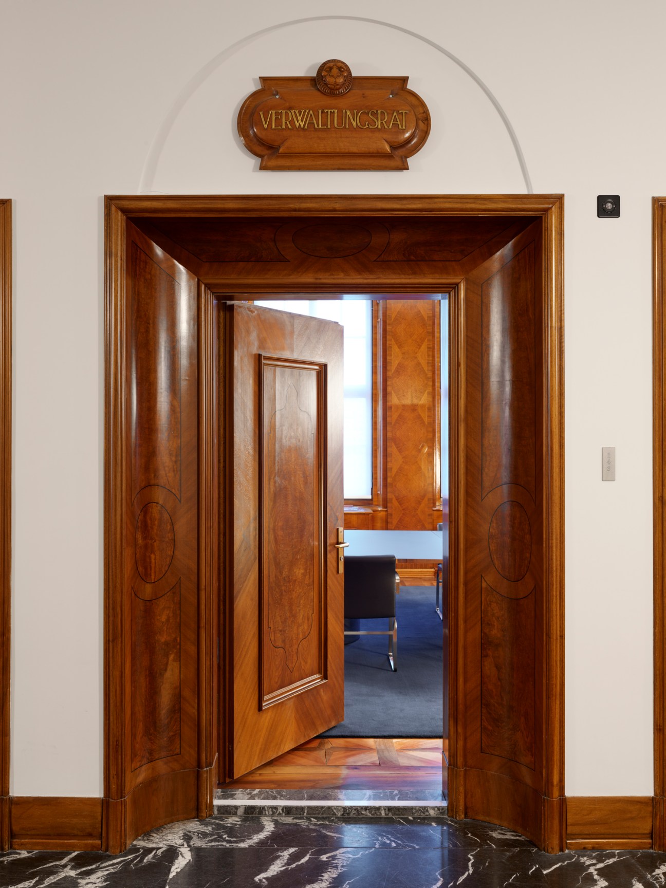 Ornate wooden doorway with 'VERWALTUNGSRAT' sign above entrance to meeting room