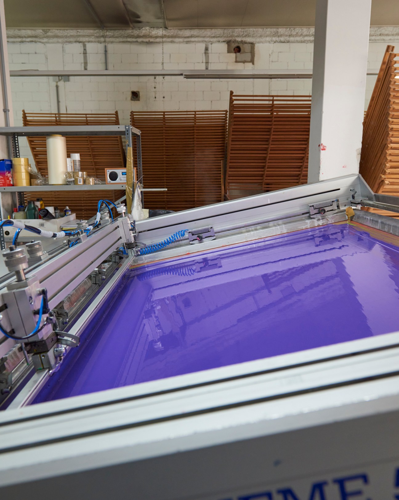 Close-up of purple ink being applied to silkscreen in the printing process