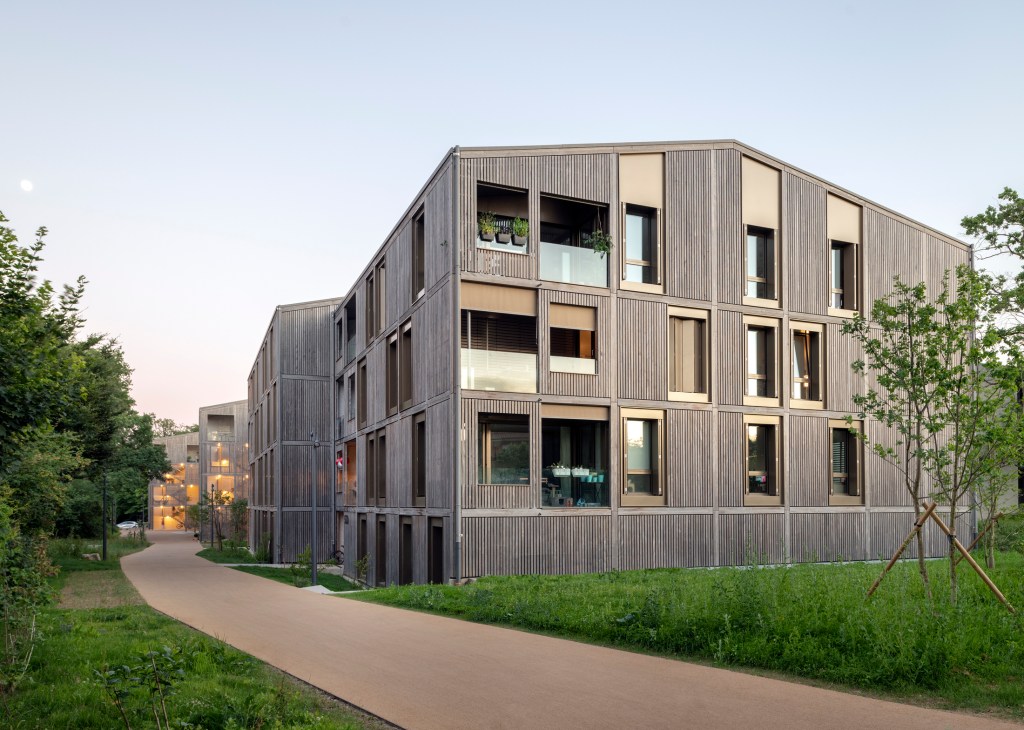 55 Rigaud housing complex exterior showing timber-clad apartments with generous balconies