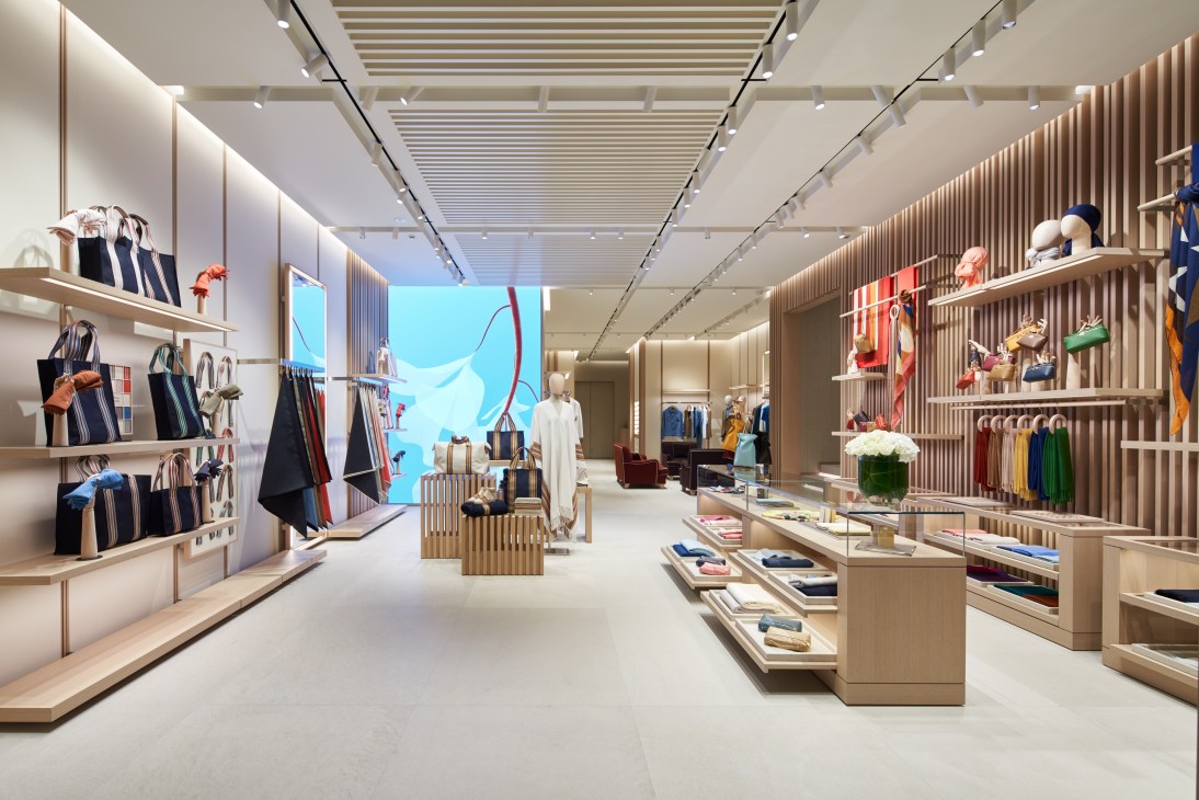 Interior view of Loro Piana Ginza store showing spacious layout with neutral tones, wooden displays, and luxury goods