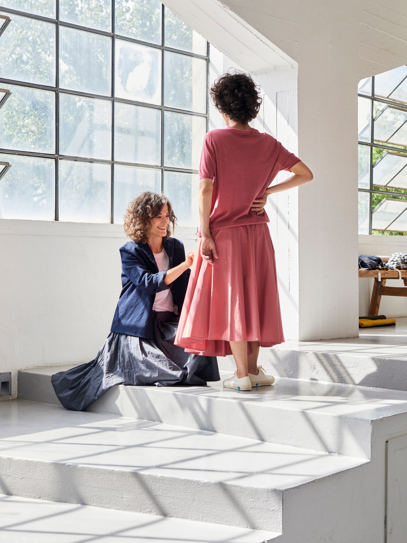Designer Barbara Garofalo fitting a red dress on a model in her bright Roman studio.
