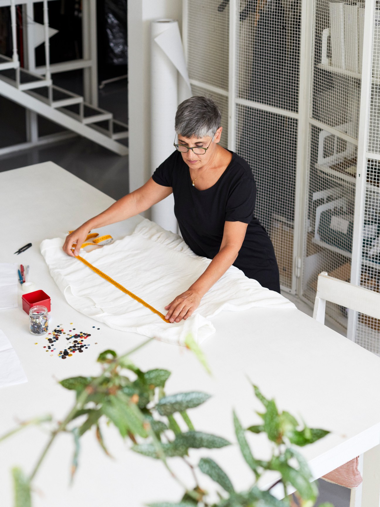 Designer Barbara Garofalo measuring fabric at her work table in the Apuntob studio.