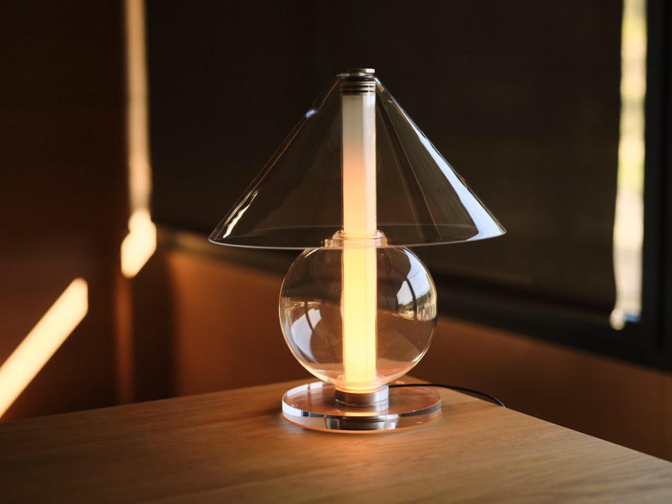 Fragile table lamp by Marset with translucent glass body creating warm ambient lighting on wooden surface