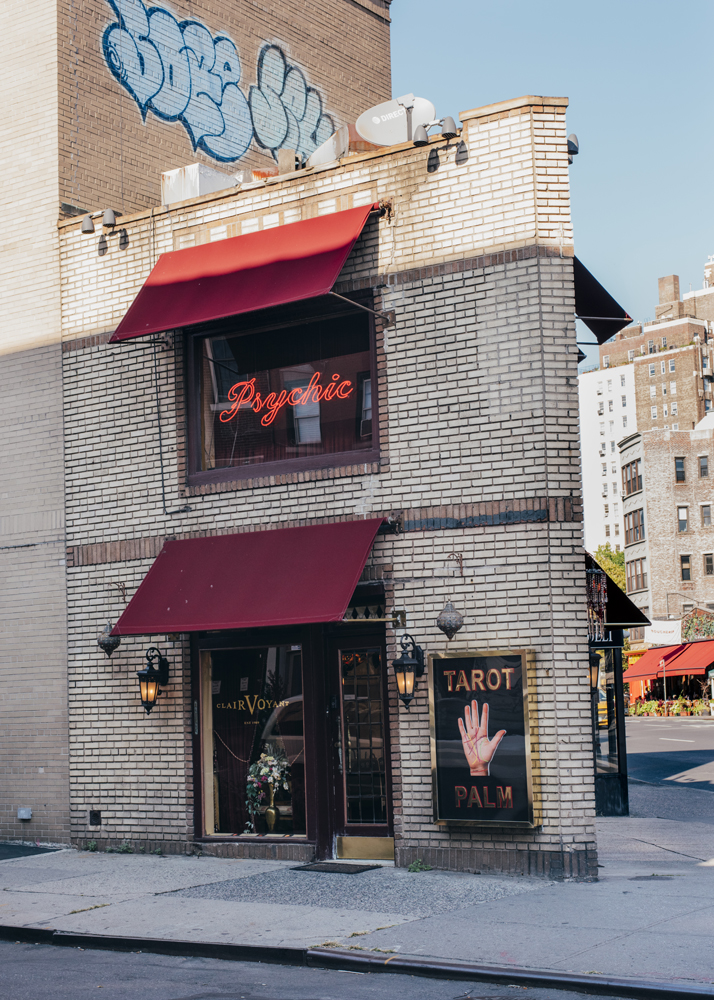 Zena Clairvoyant storefront in West Village with red awnings, neon psychic sign, and tarot palm sign.