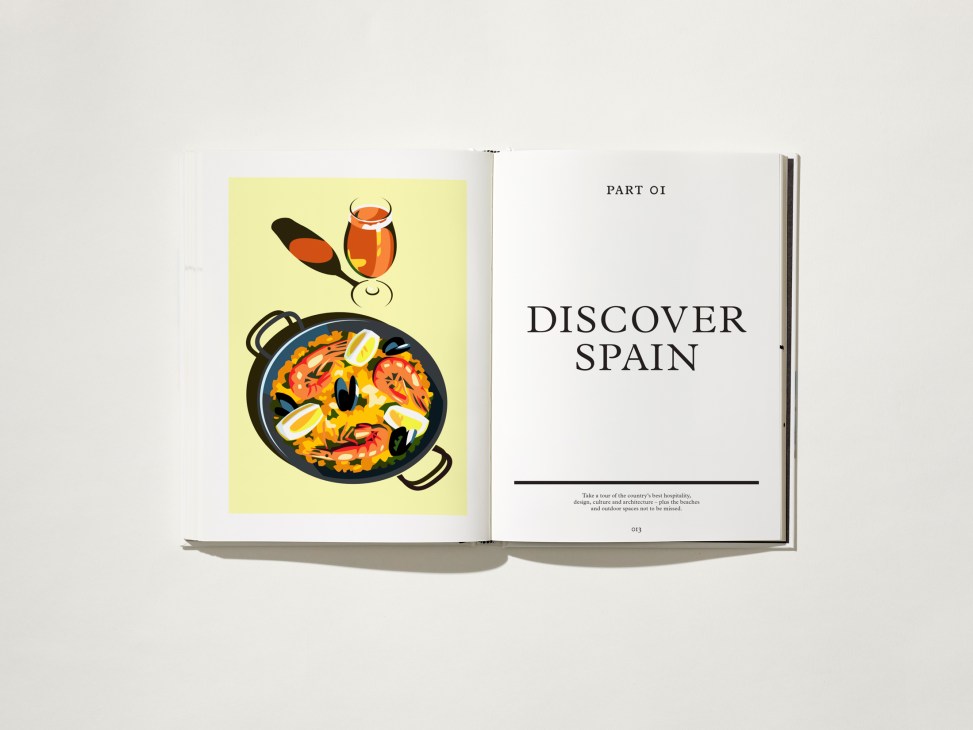 Open book showing illustrated Spanish paella and wine glass on left page, 'Discover Spain' text on right page