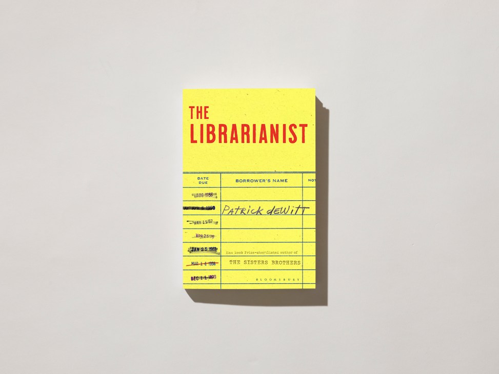 Yellow book cover of 'The Librarianist' by Patrick deWitt styled as a library checkout card with due dates