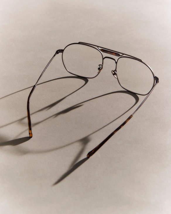 Giorgio Armani aviator sunglasses with metal frames and tinted lenses casting shadows on neutral background