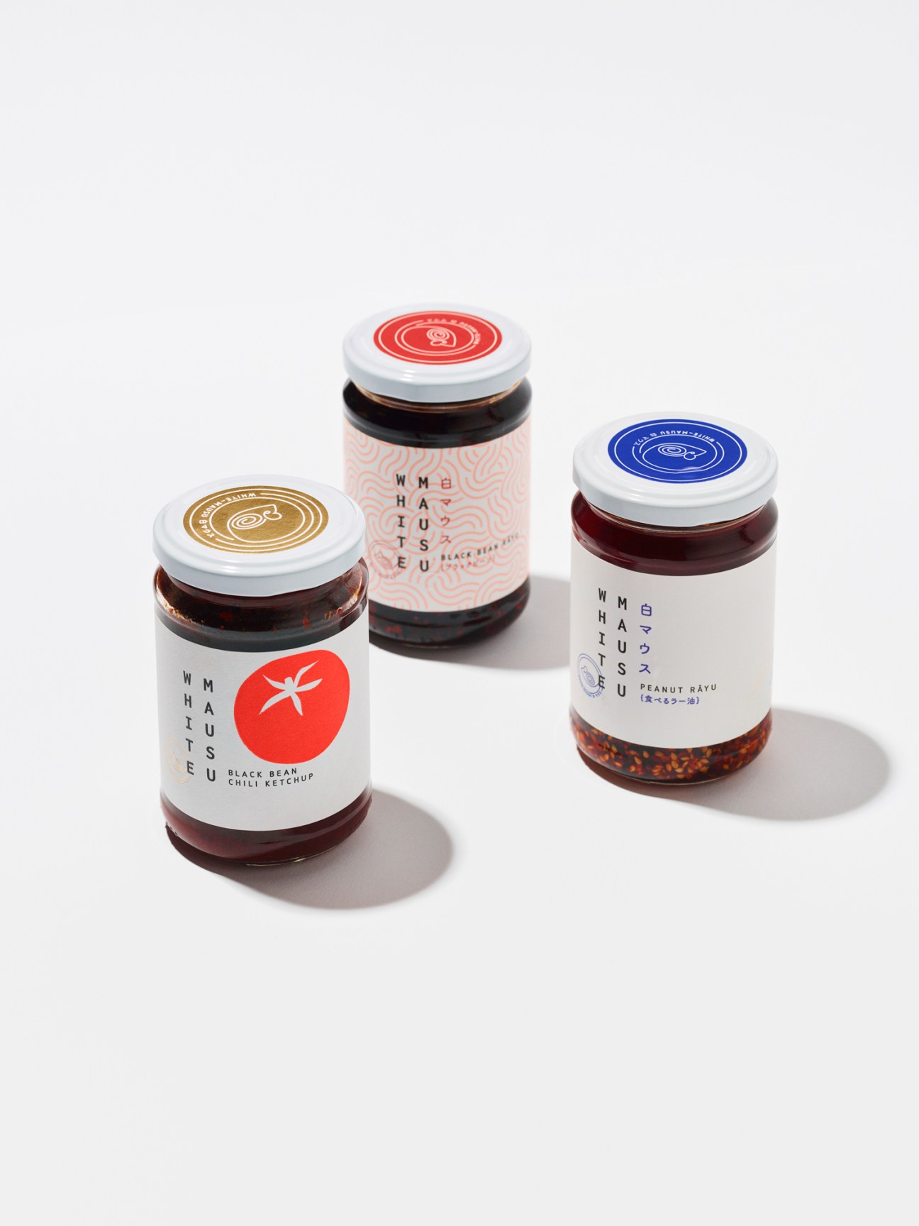 Three jars of White Mausu condiments with colorful labels and white lids against a white background