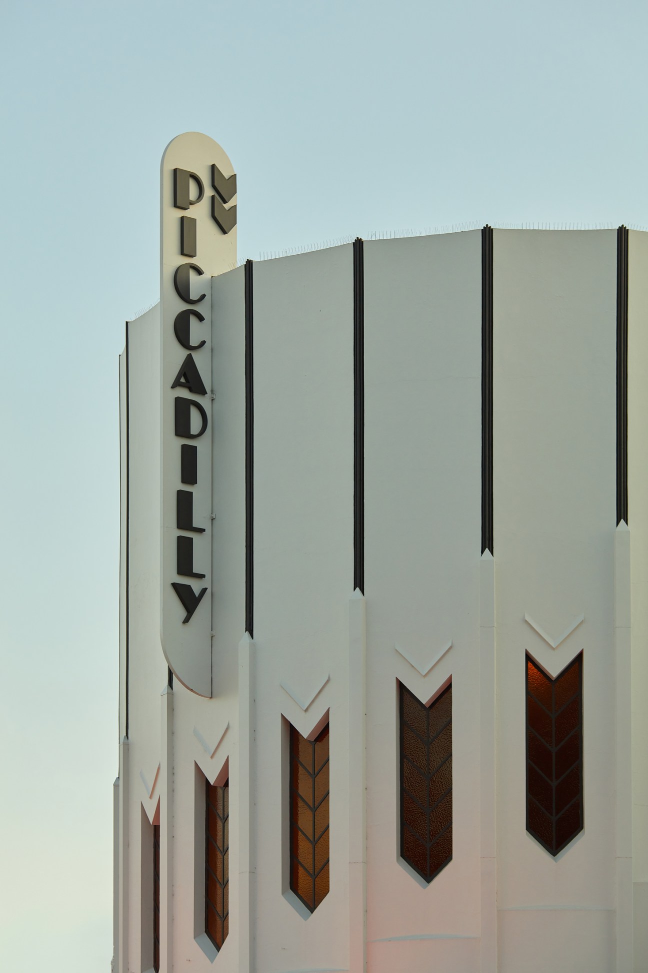 Art deco cinema facade with vertical Piccadilly sign and geometric chevron patterns